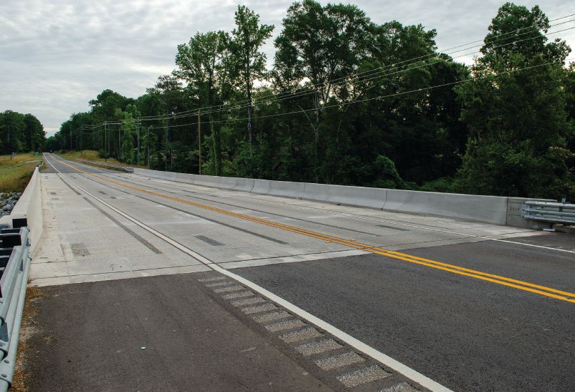 The completed bridge open to traffic. Only a 60-day road closure was necessary. The ultra-high-performance concrete closure pours and pour backs at lifting loops are visible on the surface of the deck. Photo: CHA Consulting.